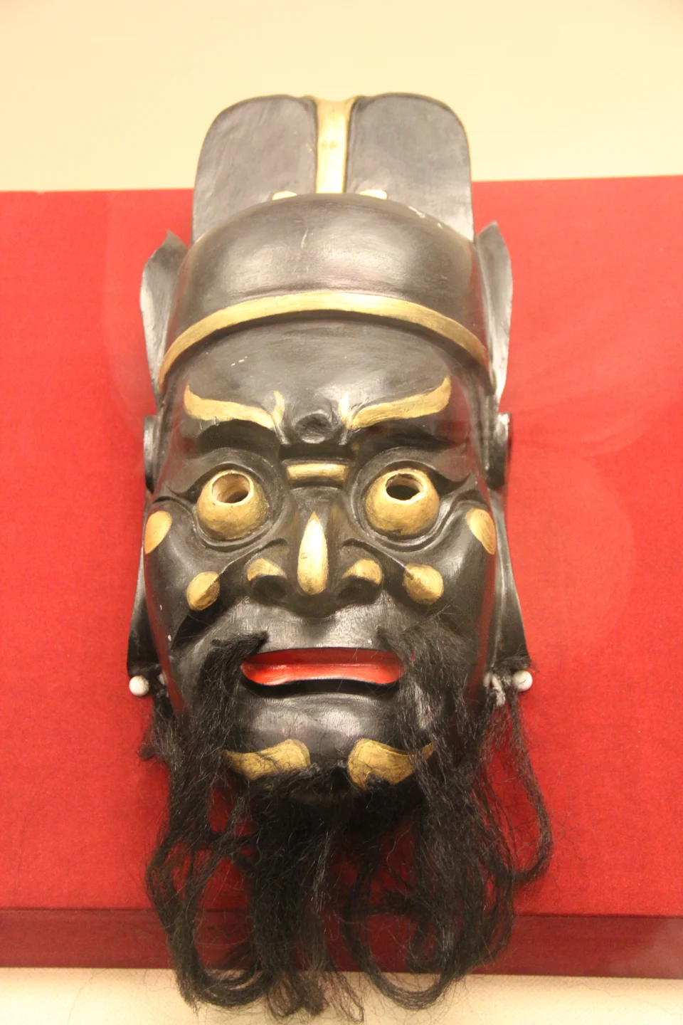 成都金沙遺址博物館特展中的儺戲面具,黑底金色眉目,配黑鬚